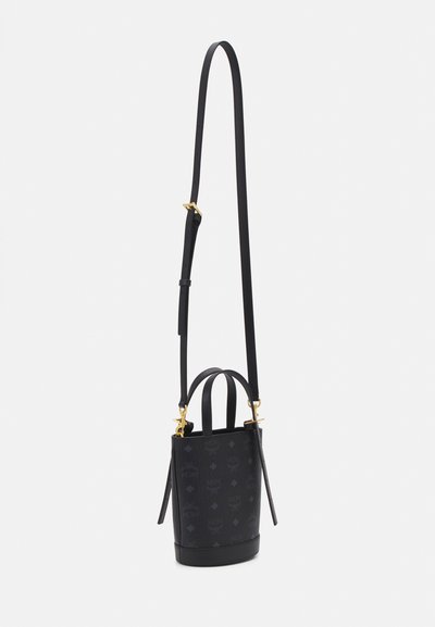 Sac seau en cuir noir avec quincaillerie dorée. Doté d'une bandoulière réglable, de deux anses supérieures et d'un motif logo en relief.