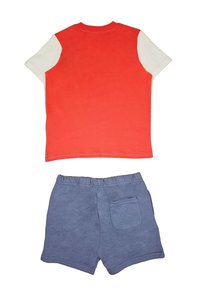 T-shirt a maniche corte rosso e bianco abbinato a pantaloni corti blu con cinturino elastico e tasca sul retro. Materiale in cotone morbido.