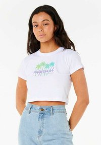 Camiseta de corte cropped blanca con un gráfico de palmera en verde y azul, y texto "Rip Curl". La tela es de algodón suave; el diseño tiene mangas cortas.