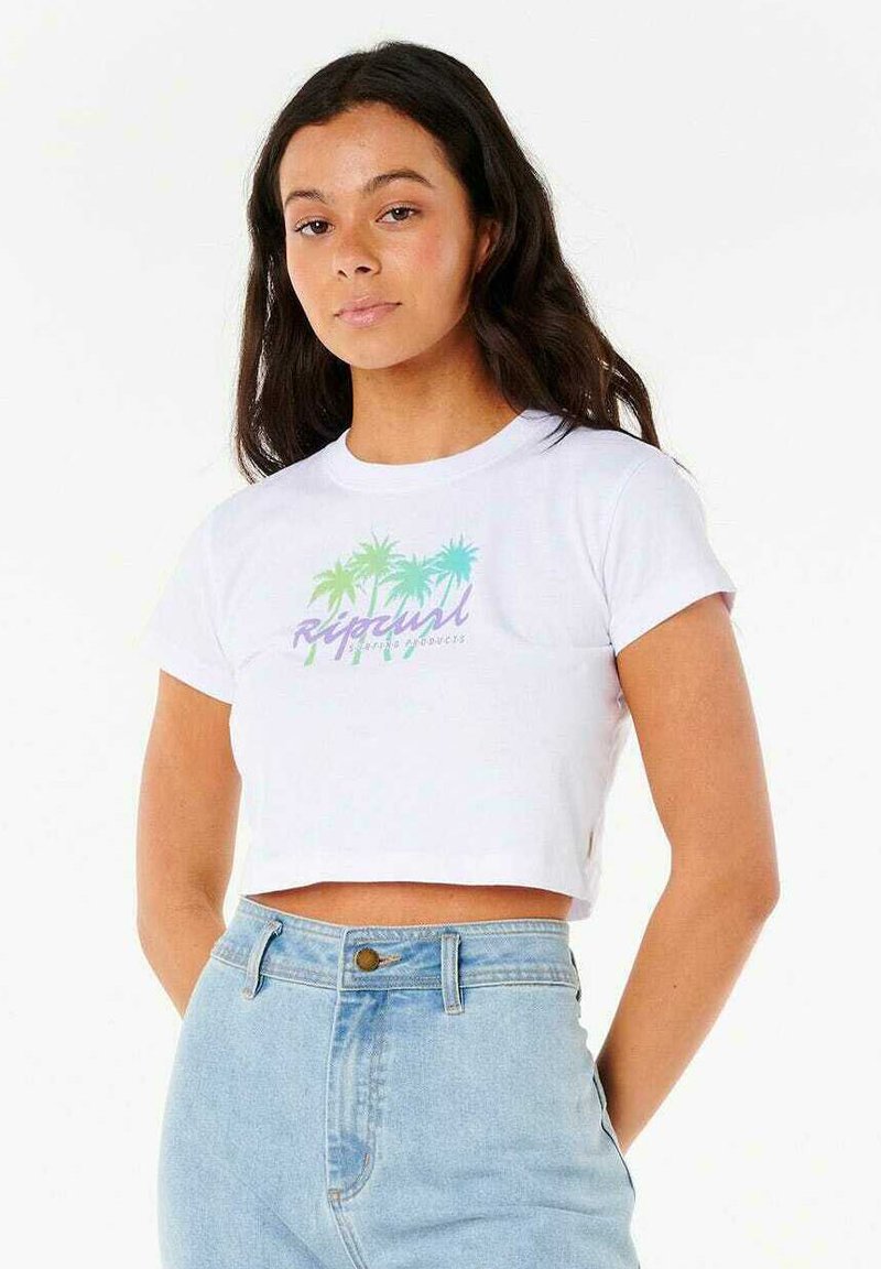 Camiseta de corte cropped blanca con un gráfico de palmera en verde y azul, y texto "Rip Curl". La tela es de algodón suave; el diseño tiene mangas cortas.