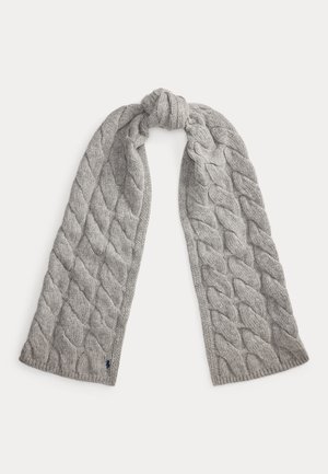 Écharpe tricotée gris clair avec de larges motifs torsadés, pliée avec un nœud en haut, étalée à plat sur un fond blanc.