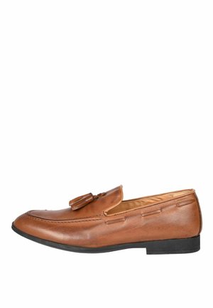 Mocassino con nappine in pelle marrone con suola nera, tacco basso e cuciture dettagliate, mostrato di lato su sfondo bianco.