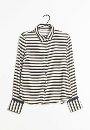 Camicia a maniche lunghe con bottoni, caratterizzata da strisce orizzontali bianche e nere con polsini in contrasto blu navy. Tessuto morbido con colletto.