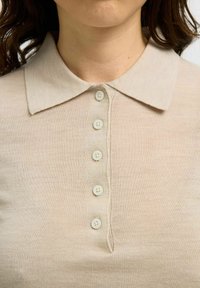 Polo shirt in knit beige con colletto e sei bottoni abbinati, dalla texture liscia e dal design slim fit.