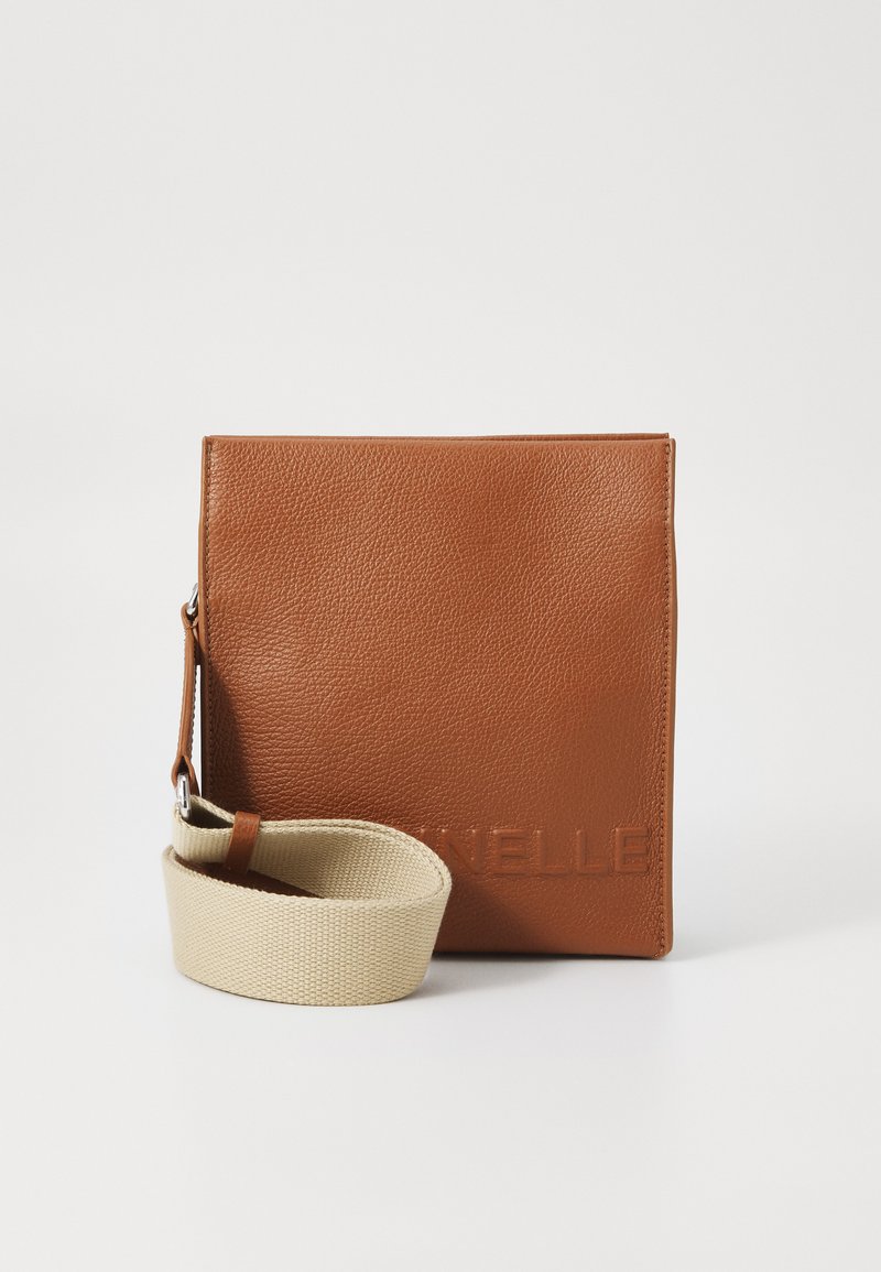 Brown leather crossbody bag with a textured surface, featuring a beige fabric strap, embossed brand name on the front, and minimalist design.