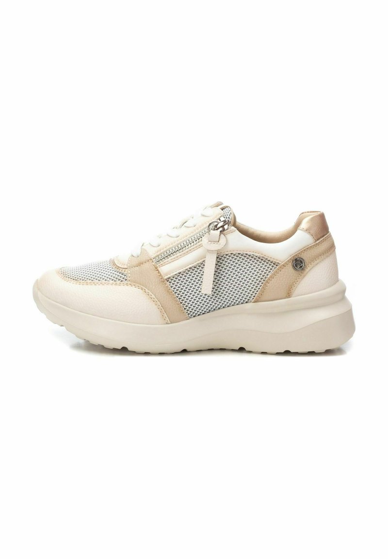 Zapatillas blancas y beige con laterales de malla, detalles de cuero suave, diseño con cordones y cremallera lateral. Suela de goma resistente, forma redondeada.