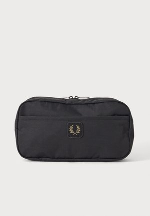 Bolsa rectangular negra con cremallera superior y bolsillo delantero, con un pequeño logo bordado con dos ramas de laurel cruzadas.