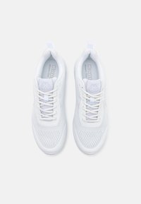 Baskets de sport blanches avec une tige en maille, des panneaux texturés et une semelle rembourrée. Elles sont dotées de lacets plats et d'un talon en boucle pour un enfilage facile.