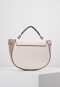 Sac à main arrondi rose pâle et beige avec bordure noire et double poignée courte, posé sur un socle blanc sur fond uni.
