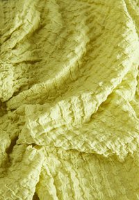 Tissu jaune texturé avec une finition froissée. Le matériau semble doux et léger, avec des motifs subtils tout au long.