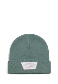Un berretto di maglia verde con texture a coste e risvolto. Presenta una toppa bianca rettangolare con testo e un grafico di skateboard.
