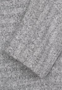 Tissu gris en maille avec une texture côtelée et des rayures verticales. Le design inclut des variations de teinte et une apparence douce et duveteuse.