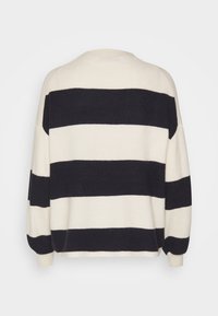 Pull en tricot avec des rayures horizontales bleu marine et crème, col rond et épaules tombantes. Texture douce et coupe décontractée.