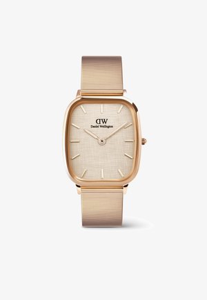 Kvadratni zlatni sat s teksturiranim bež licem, tankim zlatnim mrežastim remenom, minimalističkim oznakama sati i logotipom pozicioniranim na 12 sati.