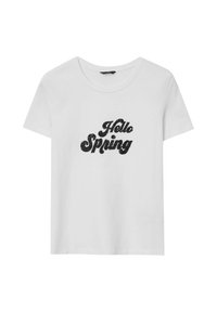 T-shirt bianco a maniche corte in cotone con stampa in glitter nera che dice "Hello Spring" in un carattere fantasioso.