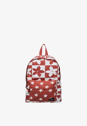 Mochila con patrón floral en rojo y blanco, bolsillo frontal con cremallera y asa superior, con una pequeña etiqueta de la marca Roxy en el bolsillo.