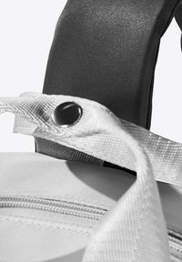 Sac en tissu blanc avec une texture lisse, doté d'une sangle grise, de quincaillerie à pression et d'une fermeture éclair. Accent sur les éléments de design fonctionnels.