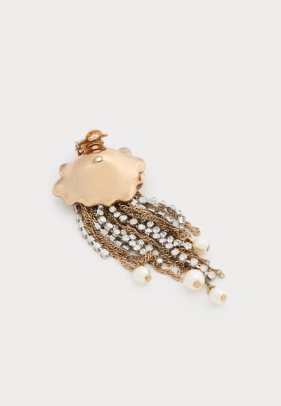 Χρυσό κλιπ μαλλιών σε σχήμα κοχυλιού με κρεμαστές αλυσίδες, στρας και χάντρες από μαργαριτάρια σε λευκό φόντο.