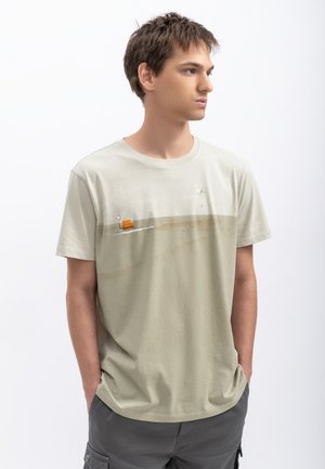 T-shirt di cotone beige chiaro con stampa minimalista di un oggetto arancione su una linea, con scollo rotondo e maniche corte.