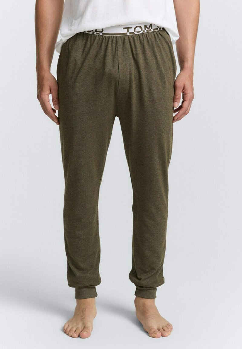 Olijfgroene joggingsbroek van zacht materiaal, met een elastische tailleband met de merknaam. Tapse pijpen met aansluitende manchetten bij de enkels.