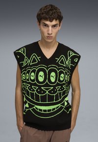 Jersey sin mangas negro con un patrón gráfico verde de gatos y ojos estilizados, con un diseño de escote en V y bordes acanalados.