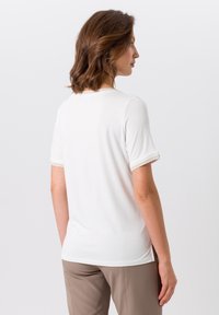 Witte T-shirt met korte mouwen en ronde halslijn, voorzien van subtiele stikdetails aan de mouwranden, zacht materiaal en een relaxte pasvorm.