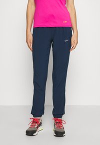 Navy athletic pants with elastic cuffs, moisture-wicking fabric, side pockets, and CMP logo in white. Worn with grey and red sneakers.