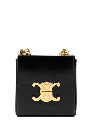 Sac à main en cuir noir avec fermoir double en forme de C doré et attaches de bandoulière en chaîne dorée sur fond blanc.
