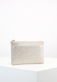 Glittrande silverfärgad kuvertväska med en slät yta, rektangulär form och dragkedjestängning upptill. Lämplig för att bära små föremål.