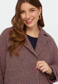 Palton din tweed țesut în nuanțe multicolore de roz, albastru și violet, cu guler tip notch, închidere cu nasturi și țesătură texturată.