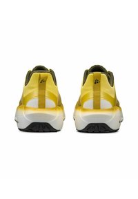 Baskets de sport jaunes et vertes avec un dessus texturé, une languette à l'arrière et une semelle contrastante blanche et noire, présentant un détail de logo.