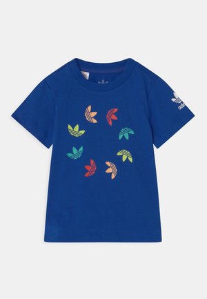 Niebieski T-shirt z krótkim rękawem z wielokolorowymi logo koniczyny Adidas tworzącymi okrąg na przodzie oraz białym logo koniczyny na lewym rękawie.