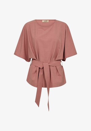 Putekļainas rozā krāsas īss piedurkņu blūze ar platiem piedurknēm un atbilstoša auduma josta, kas sasieta ap vidukli.