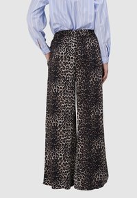 Luipaardprint wijde pijpen broek met een zwart en beige kleurenschema; elastische tailleband; zachte stof; subtiele glans; twee zijzakken.