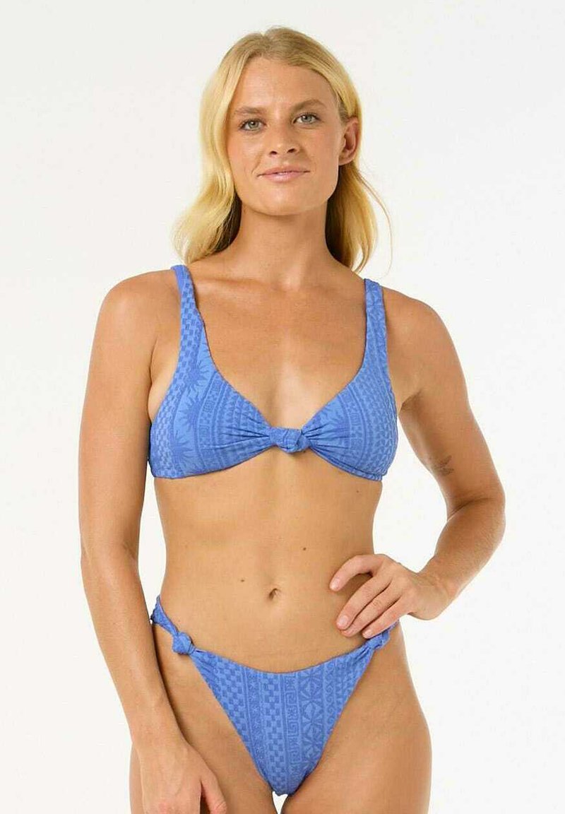 Niebieski zestaw bikini z trójkątnym biustonoszem z węzłem z przodu i dopasowanymi regulowanymi majtkami. Wzorzysty materiał dodaje wizualnego zainteresowania.