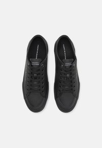 Baskets à lacets noires en cuir, dotées d'une texture lisse, d'un bout rond et de semelles intérieures marquées du logo "Tommy Hilfiger".