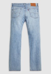 Jeans de mezclilla azul claro con patas rectas, que presentan dos bolsillos traseros, costuras en contraste y un parche de cuero marrón con la marca en la cinturilla.