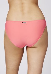 Rosa Bikini-Höschen aus glattem Stoff, mit mittelhohem Schnitt, minimaler Abdeckung und abgesteppten Details. Auf der Rückseite befindet sich ein kleines schwarzes Markenlogo.