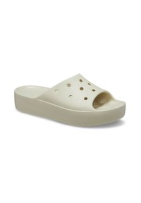 Scarpa slip-on beige chiaro con punta aperta, dotata di fori di ventilazione e suola a piattaforma strutturata per una maggiore aderenza. Realizzata in materiale morbido e resistente.