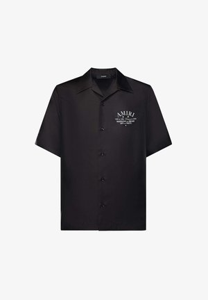 Chemise noire à manches courtes avec col, boutons, logo "AMIRI" blanc et texte sur la zone de la poche poitrine gauche.