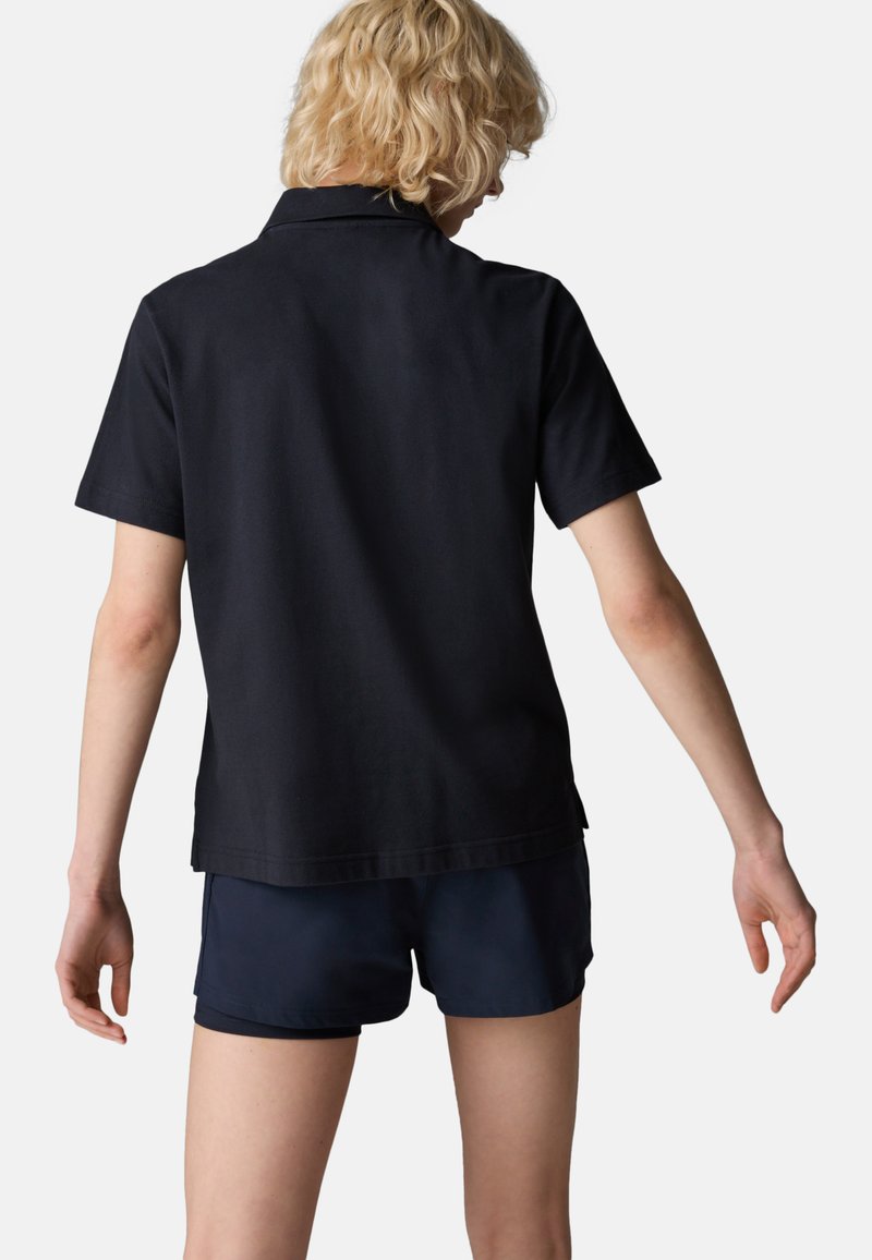 Schwarzes Polo-Shirt aus Baumwolle, mit einem klassischen Kragen und kurzen Ärmeln, kombiniert mit navyfarbigen Shorts, die eine glatte Textur aufweisen.