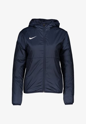 Giacca puffer blu navy con cerniera, cappuccio e logo Nike bianco sul lato sinistro del petto; presenta polsini elasticizzati e una texture liscia.