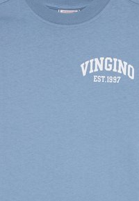 Šviesiai mėlyna crew neck tipo džemperis su balta užrašu "VINGINO EST. 1997" viršutinėje kairėje krūtinės pusėje.
