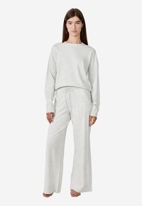 Lichtgrijze katoenen loungewear set met een ontspannen sweater met ronde hals en wijde broek met een trekkoord in de taille. Zachte textuur.