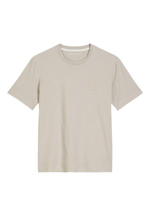 Beżowa koszulka z krótkim rękawem wykonana z miękkiej bawełny. Posiada okrągły dekolt i delikatne wytłoczone logo w górnym lewym rogu.