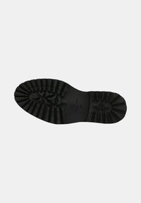 Semelle de chaussure en caoutchouc noir avec des rainures profondes, présentant une surface texturée et une forme profilée et supportive pour une traction et une stabilité optimales.