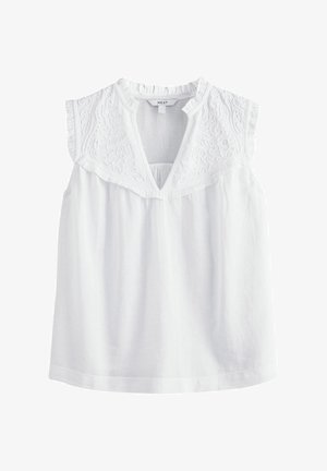 Biela bezramenná blúzka s vyšívanými detailmi na výstrihu, textúrovaná tkanina a uvoľnený strih. Obsahuje výrez v tvare písmena V.