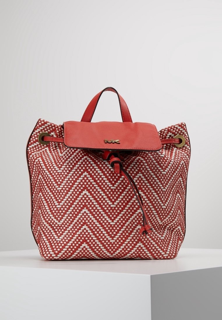 Sac à main tissé rouge et blanc avec motif en chevrons, rabat supérieur en cuir, fermeture avec cordon de serrage, et une poignée courte. Présente des accents de quincaillerie dorée.
