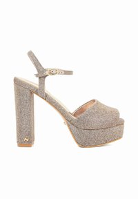Hoge hak sandaal met een beige glitterstof, open teen, verstelbare enkelband en een dikke blokhak met een gouden accent.