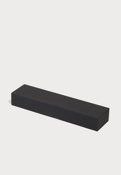 Caja rectangular negra con acabado mate, con marca grabada en un costado. Diseño suave y minimalista sin patrones adicionales.